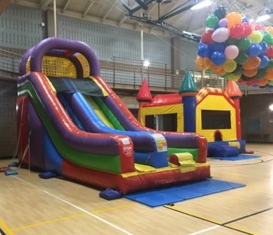 Giant inflatable slide with bounce house inside community center